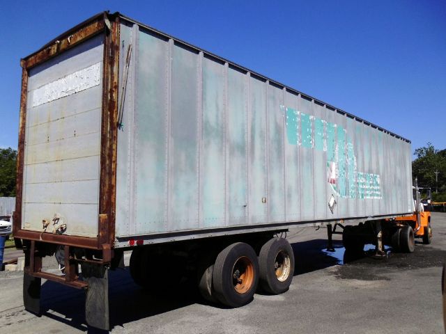 Fruehauf F69-F2-45 trailer side and rear showing metal panels, dual rear wheels, and aging paint with rust framing.