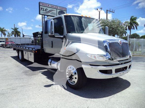 International MV tow truck front/side view with flatbed, chrome bumper, and large grille.