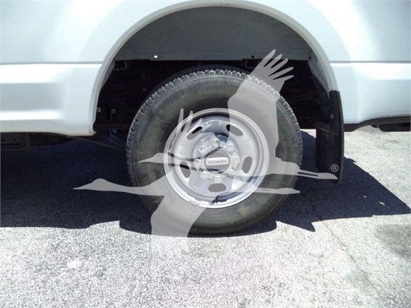 Ford F-250 wheel and front fender showing stock wheel and tire in a dump truck.
