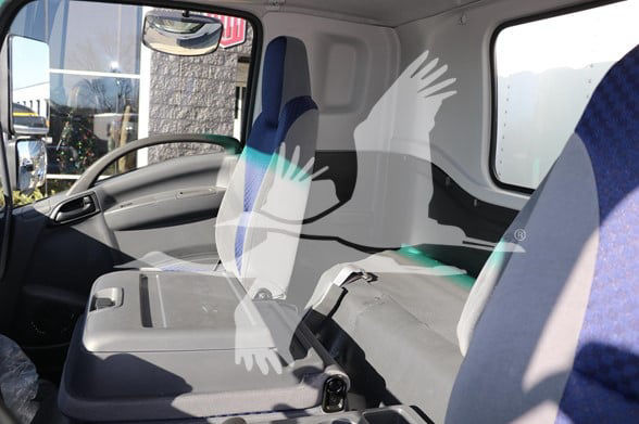 Isuzu FTR cab interior showing driver seat, passenger seat, and cargo area.