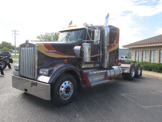 Kenworth W900-conventional sleeper truck, side view showing large chrome exhaust stacks, polished fuel tanks, and chrome grille.