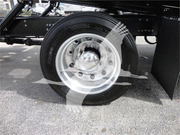 Wheel and tire of a Mack MD6 truck showing a steel wheel with multiple lug holes and center cap, part of a chassis frame.