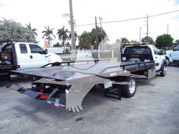 Tow truck flatbed with Ram 5500 SLT listing. Visible text includes stock number J40687 and category Tow.