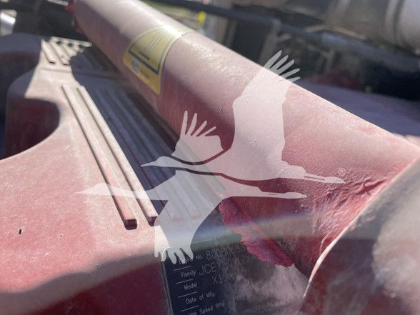 Kenworth T800 engine bay area showing a red/pink component with a warning label and a metal plate with model and date information partially visible.