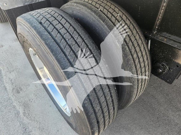 Trailer dual wheels showing tire treads and metal wheel hubs.