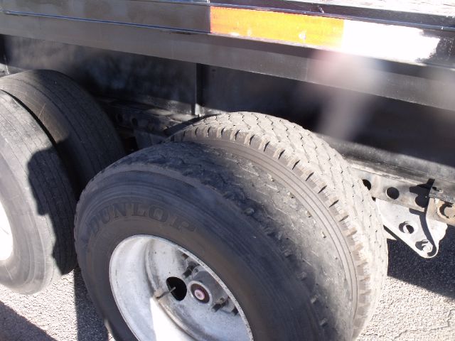 Wheel end of a 2005 Fontaine flatbed expandable trailer showing dual rear tires and part of the frame.