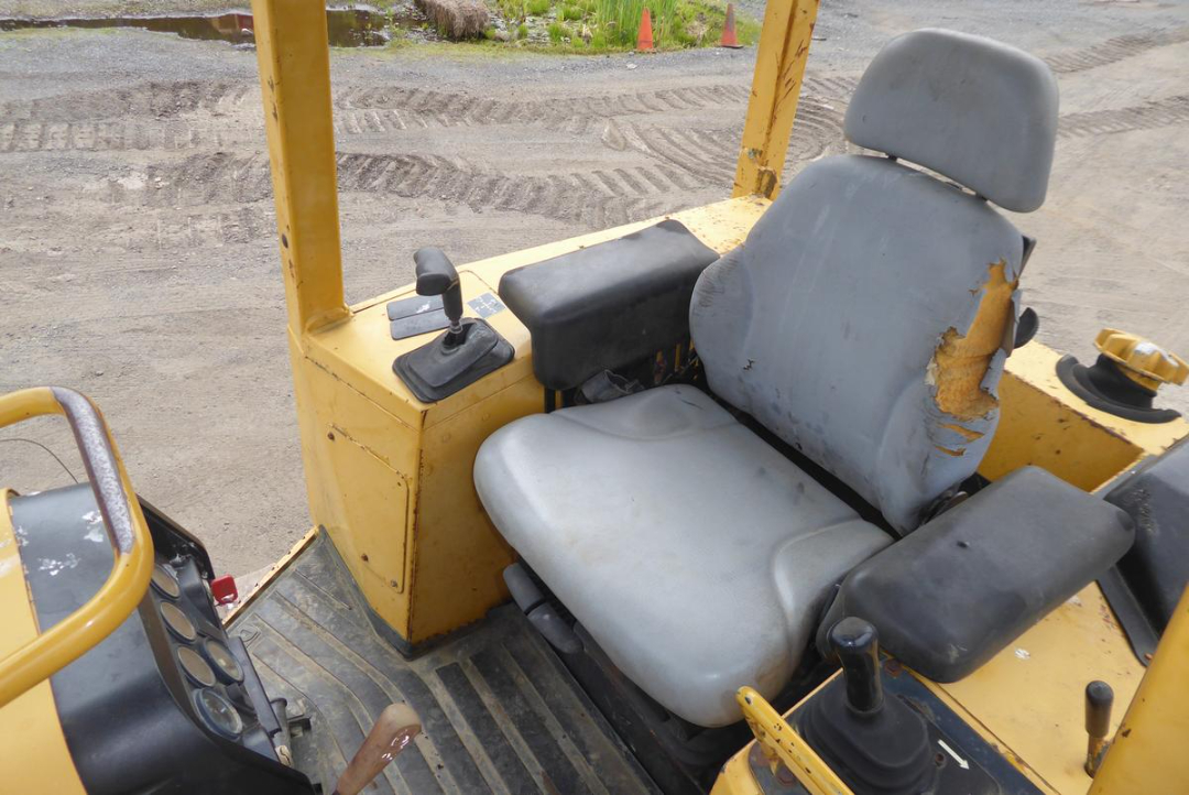 John Deere 650HLT dozer cab interior showing grey seat and control levers.