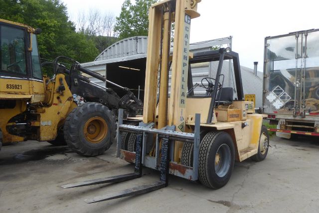 Caterpillar V225 forklift in yard showing forks and tall vertical mast with 'CATERPILLAR' branding.