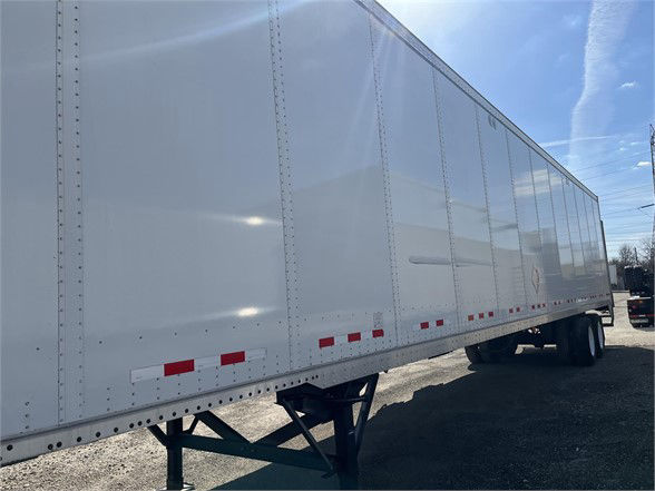A white Vanguard dry van trailer side view with no visible branding text, stock number 847912 VAN, and triangular landing gear visible near the front.