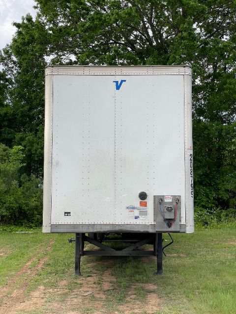 Rear view of a white 53 ft Vanguard trailer, with ramp door and hitch, parked on grass, side-mounted logo and small decals visible.
