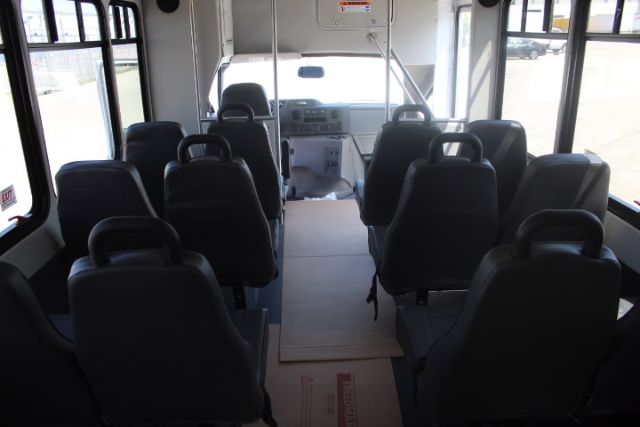 Ford E450 shuttle bus interior with arranged seating and driver cockpit visible at front.