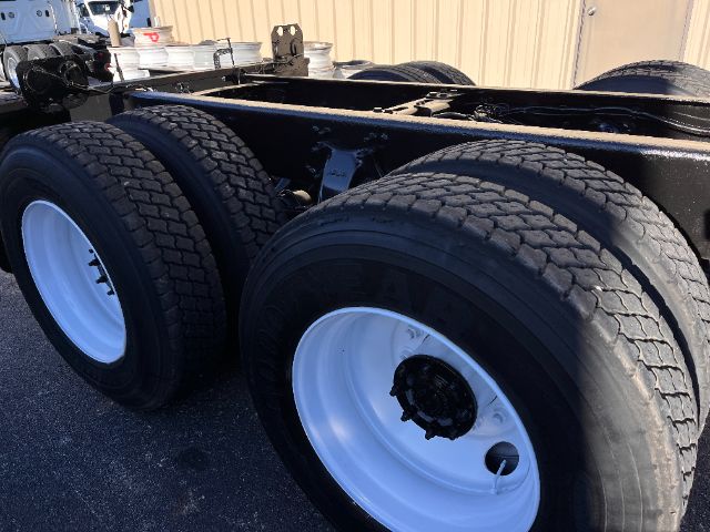 Freightliner M2 chassis showing dual rear axles with large tires and white steel wheels.