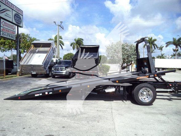 Tow truck trailer with lightweight MV-series cab? No, it shows a flatbed tow truck with a gooseneck style car hauler and tilt-bed; visible wheel, ramps, and hydraulic system. License plate not visible.