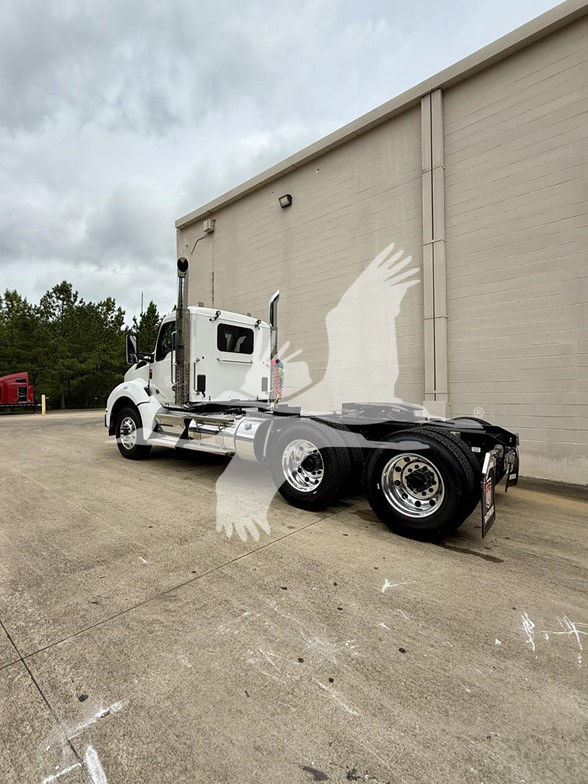 Kenworth T880 conventional daycab tractor with white cab, dual rear axles, chrome wheels, and fifth wheel visible.