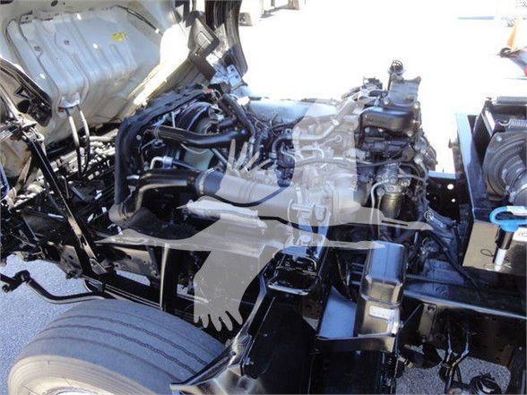 Isuzu NRR engine bay visible with various hoses and components; area shows engine block, intake manifold, and surrounding chassis.