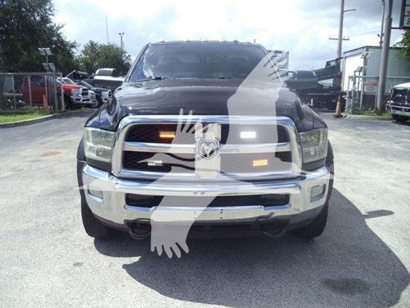 Ram 4500 front view showing chrome grille, headlights, and bumper with tow hooks; light reflection on hood and windshield.