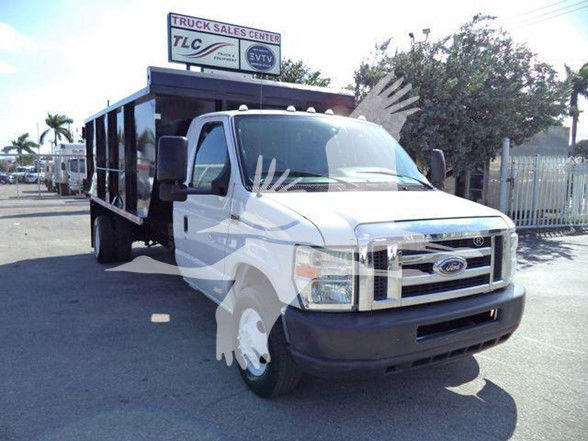 2011 Ford E450 dump truck in parking lot with front grille, side mirrors, and dump bed visible.