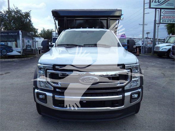 Front view of a white 2022 Ford F-550 dump truck with large grille and chrome bumper.