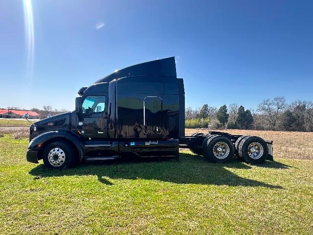 Peterbilt 579 truck in black, side profile, sleeper cab, dual rear axles, no trailer attached.