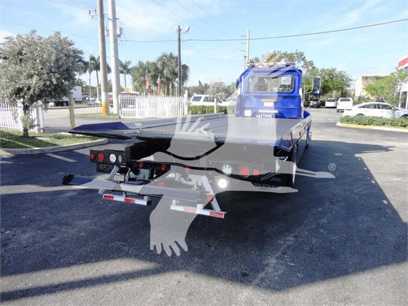 2022 Peterbilt 337 tow truck rear view showing bed and hitch setup with tail lights and bumper.