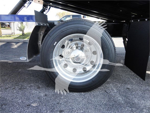 Peterbilt 337 wheel and dual rear axle area showing polished aluminum rim and tire, with black undercarriage and fender mud flap.