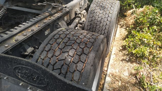 Peterbilt tractor cab chassis showing dual rear tires and tread, drivetrain frame, and components visible in the wheel area.