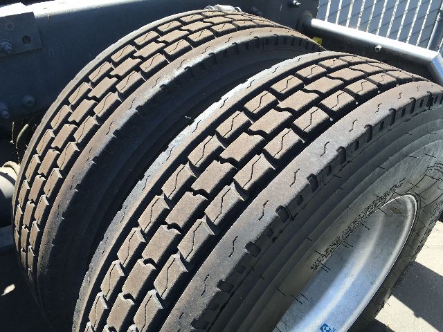 Tandem rear wheels on a Freightliner Cascadia 125 truck, heavy-duty tires with detailed tread pattern and wheel rims.
