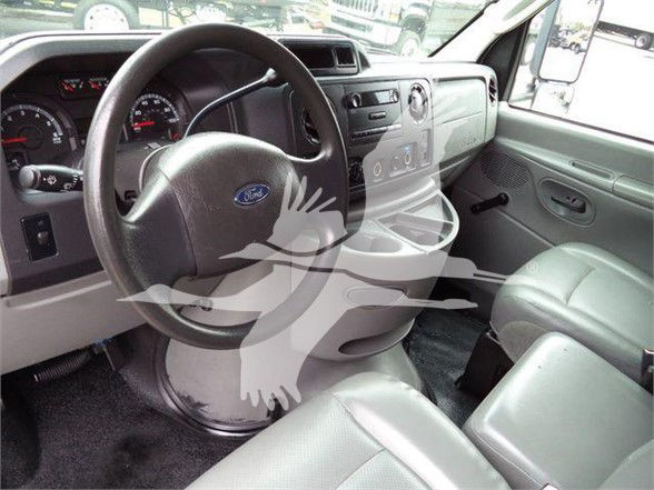 Ford E-Series van interior showing steering wheel, dashboard, driver seat and front passenger seat.