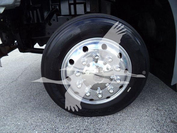 Truck front wheel showing steel rim and tire, undercarriage of a Hino 258ALP tow truck.