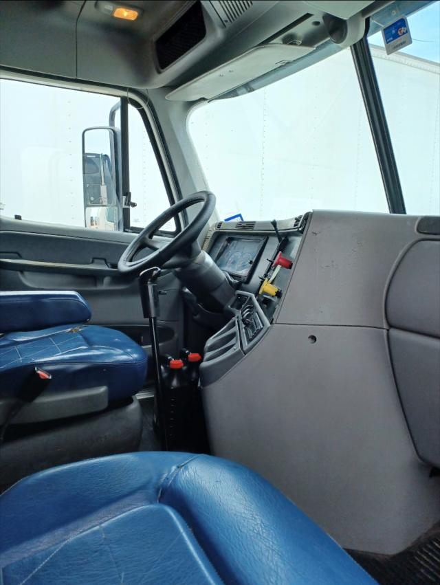 Truck cab interior of a 2007 Freightliner Columbia showing steering wheel, dashboard, and blue leather seats.