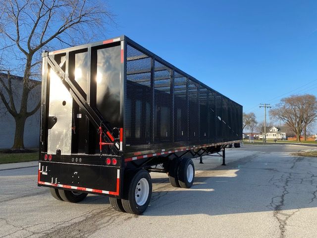 2008 Transcraft 48 ft aluminum mesh trailer for car carrier with black side walls, dual rear doors, and tandem axle dual tires; reflective safety striping along lower edge.
