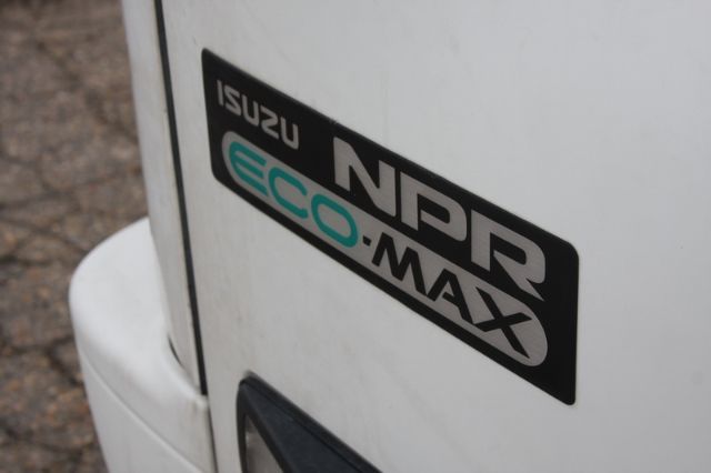 Isuzu NPR-HD Eco-Max badge on white truck exterior, partial rear corner visible.