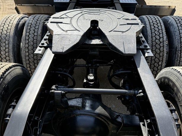 Tractor-trailer chassis with rear drive axles and fifth wheel, showing drivetrain components and suspension, viewed from above.