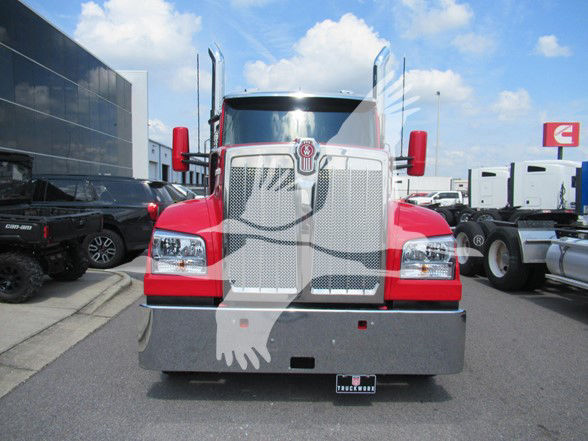 Kenworth W990 front view showing chrome grille, large bumper, dual exhaust stacks, red hood and side mirrors.