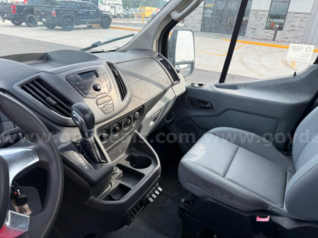 Ford Transit cabin interior showing front passenger seat and center console with gear selector and cup holders.