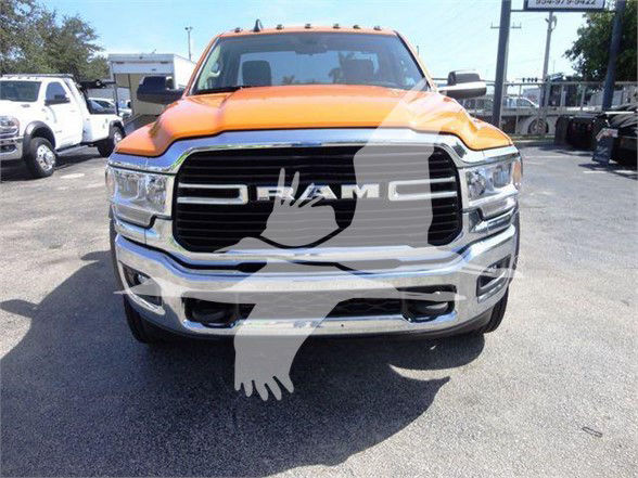 Front view of a vibrant orange 2024 Ram 4500 SLT pickup truck with large black grille and chrome bumper; visible RAM lettering on grille; watermark across image.