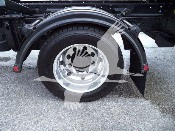 Truck wheel and fender on a 2023 Chevrolet Silverado 6500HD chassis; visible tire, chrome wheel, black mudguard, and surrounding chassis.