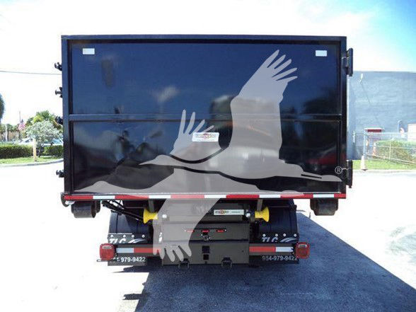 Rear view of a 2023 Chevrolet Silverado 6500HD service body/dump truck trailer with a large black dump bed and graphic of birds in flight on the side.