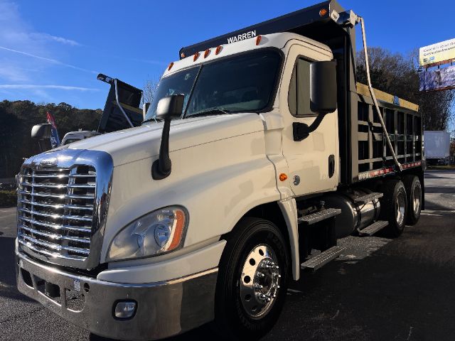 Dump truck showing Freightliner Cascadia 125 cab and dump bed with chrome grille and bumper.