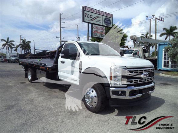 Ford F-550 tow truck with white cab and flatbed, front grille and bumper visible, TLC Truck & Equipment logo watermark.
