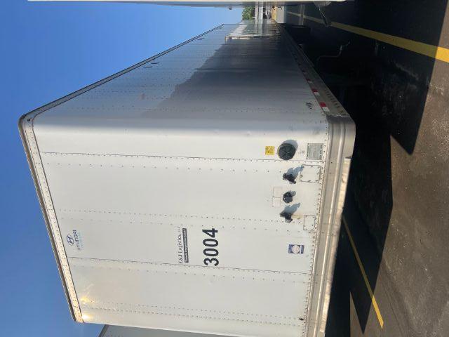 Hyundai trailer with rear doors, side panel numbers 3004, small logos and warning stickers; visible circular coupling hardware at bottom right; tall rectangular Perkins? enclosure; no mobile equipment visible.