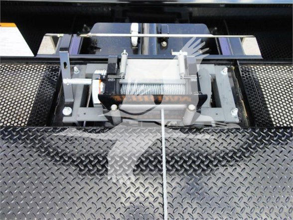 Tow truck winch and mount assembly on diamond plate bed with winch drum, hook, and steel cables visible.
