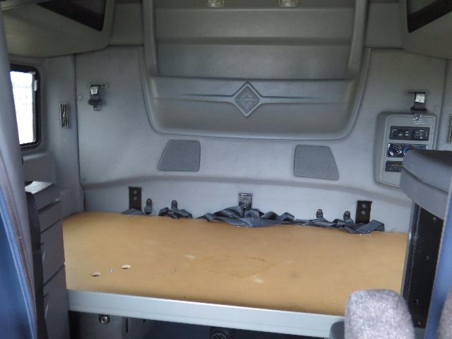 Interior sleeper cab of a 2010 International PROSTAR showing a beige bunk bed with side panels and storage pockets.
