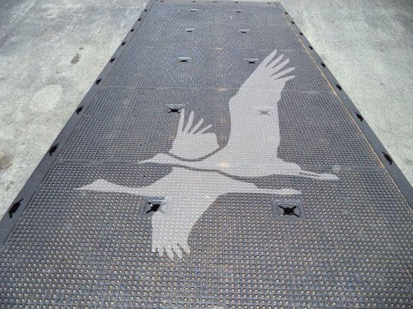 Flatbed trailer surface with a large white bird logo (falcon) in the center on a textured metal deck.