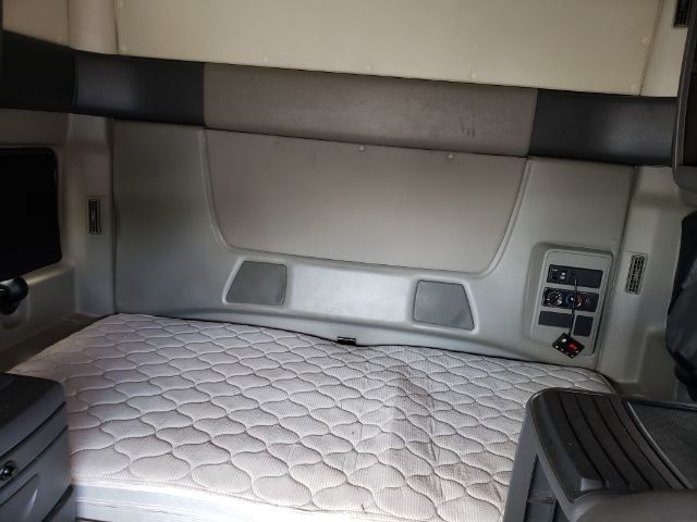 Interior sleeper cab area of a 2015 International PROSTAR showing sleeper bunk with quilted mattress, side control panel, and storage panels.