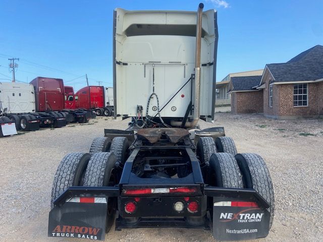 Rear view of 2015 Mack CXU613 cab and chassis showing dual rear axles and fifth wheel area with wiring harnesses.