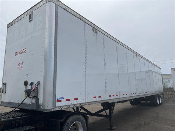 Vanguard VXP trailer in a side view showing mostly silver aluminum exterior with red and white reflective markers along the lower edge.