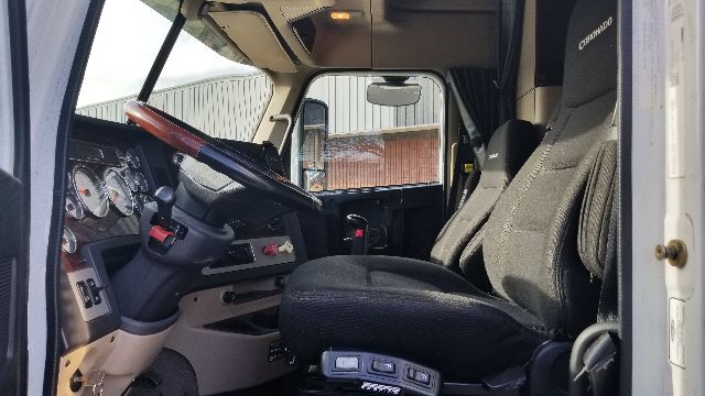 Freightliner Coronado 132 truck interior showing steering wheel, dashboard gauges, and driver seat in view.