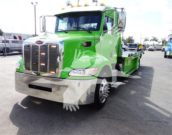 Green 2022 Peterbilt 337 tow truck front view with chrome grille and dual headlights.
