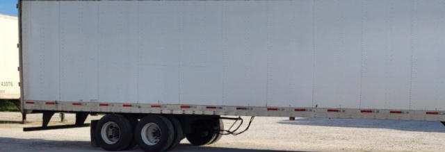Trailer side view showing utility composite trailer with tandem axles and reflective tape